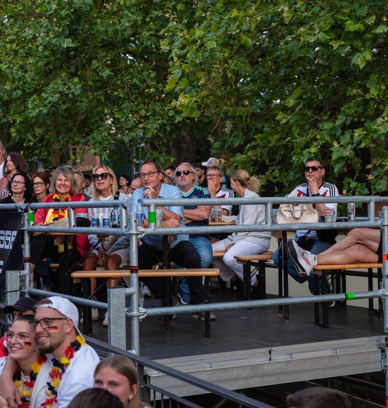 Gäste auf der Tribüne verfolgen das Spiel